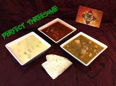 Three bowls side by side, chile con queso, red chile and green chile stew, with a folded flour tortilla