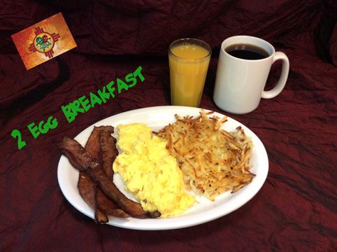 The two egg breakfast: scrambled eggs, bacon and hash browns with a glass of orange juice and a mug of coffee